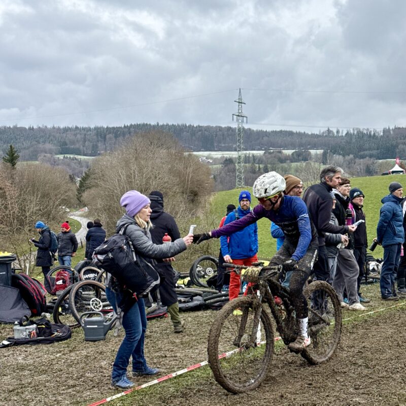 Paul Schrecker nimmt in der letzten Runde ein Gel in der Feed Zone des Rennens